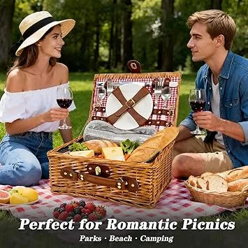 Couple enjoying outdoor picnic using insulated basket with glasses on blanket