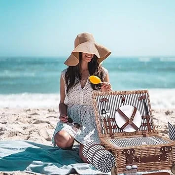 Couple enjoying outdoor wedding picnic with wicker basket and blanket setup