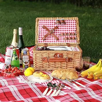 Couple enjoying outdoor picnic with two person wicker basket on grass