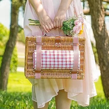 Couple enjoying outdoor picnic with red wicker basket on blanket