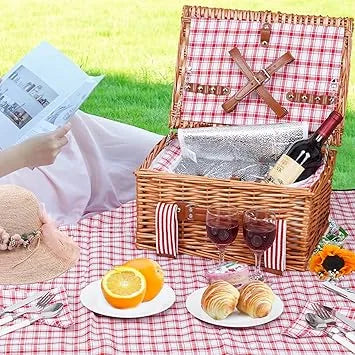 Red wicker picnic basket displayed next to cutlery service kit